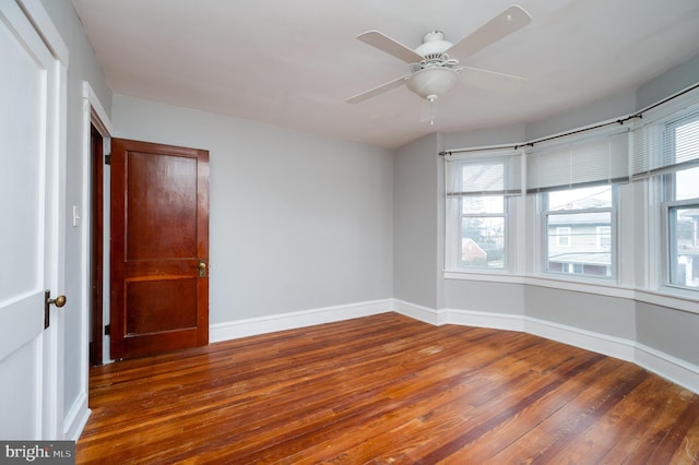 unfurnished room with dark wood-type flooring and ceiling fan