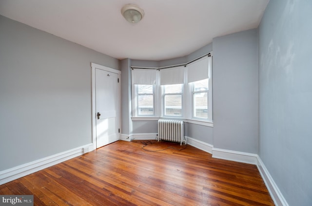 spare room with radiator and hardwood / wood-style floors