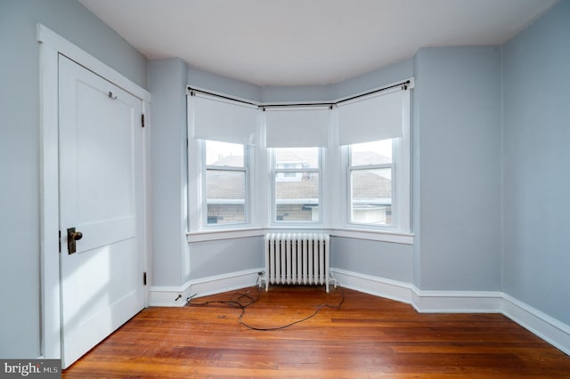 interior space with radiator, hardwood / wood-style floors, and plenty of natural light