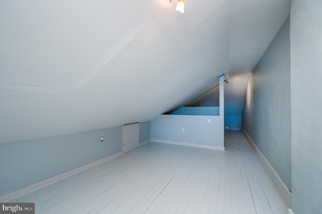 bonus room with vaulted ceiling and light hardwood / wood-style flooring