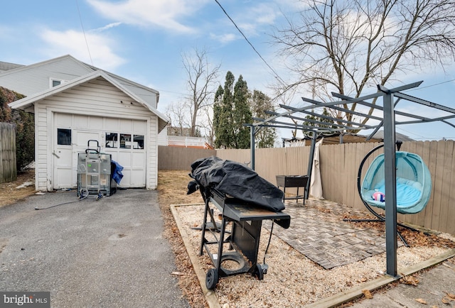 view of yard with a garage, an outbuilding, and a pergola