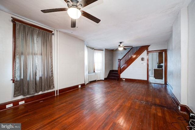 unfurnished living room featuring radiator heating unit, ceiling fan, and dark hardwood / wood-style floors