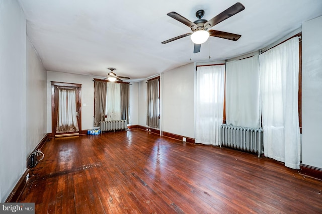 unfurnished room featuring dark hardwood / wood-style floors, radiator heating unit, and ceiling fan