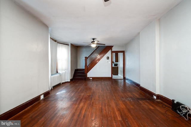 unfurnished living room with dark hardwood / wood-style floors, radiator heating unit, and ceiling fan