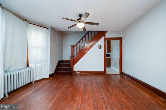 unfurnished room featuring radiator heating unit, ceiling fan, and dark hardwood / wood-style floors