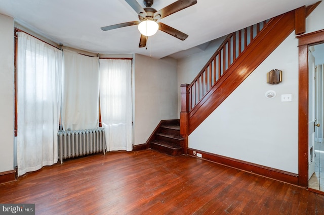 spare room with dark hardwood / wood-style floors, radiator heating unit, and ceiling fan