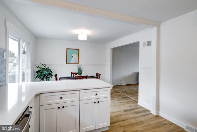 kitchen with light countertops, visible vents, and white cabinets