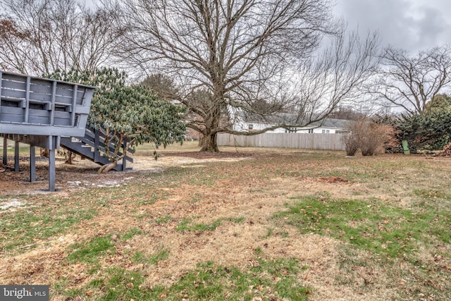 view of yard featuring fence and stairs