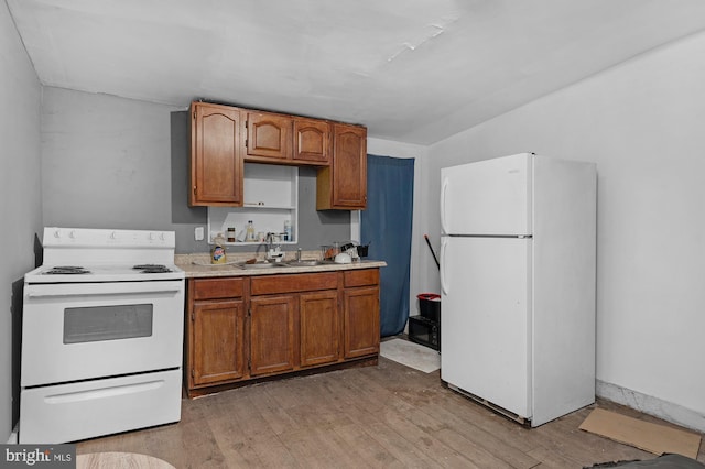 kitchen with white appliances, light hardwood / wood-style floors, and sink