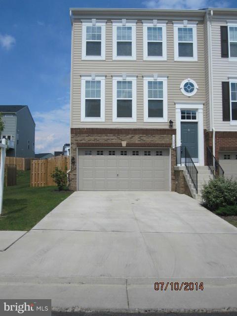 view of front of house with entry steps, driveway, an attached garage, fence, and brick siding