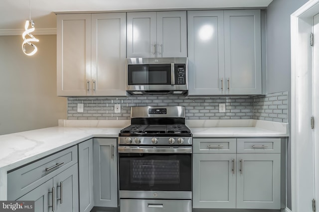 kitchen featuring appliances with stainless steel finishes, gray cabinets, pendant lighting, and decorative backsplash