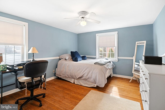 bedroom with light wood-style flooring, baseboards, and ceiling fan