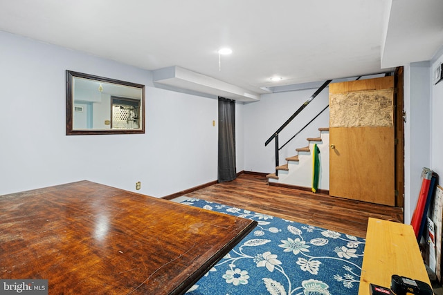 interior space featuring dark wood finished floors, baseboards, and stairway