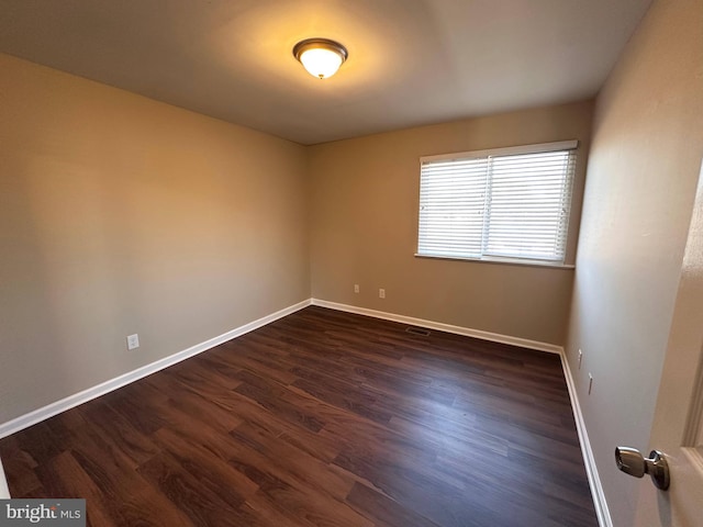 spare room with dark hardwood / wood-style flooring