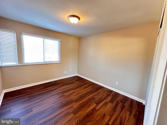 spare room featuring dark hardwood / wood-style flooring