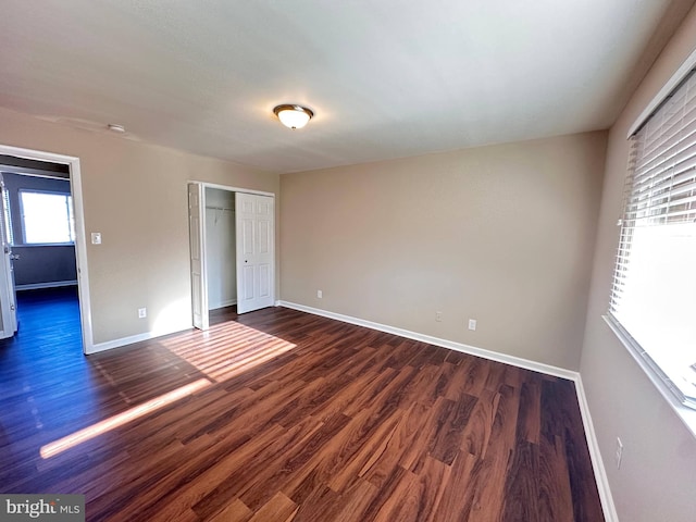 unfurnished bedroom featuring a closet and dark hardwood / wood-style floors