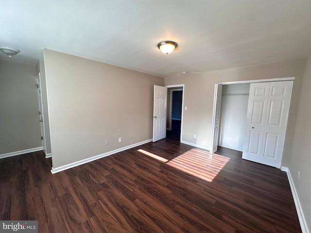 unfurnished bedroom featuring a closet and dark hardwood / wood-style flooring