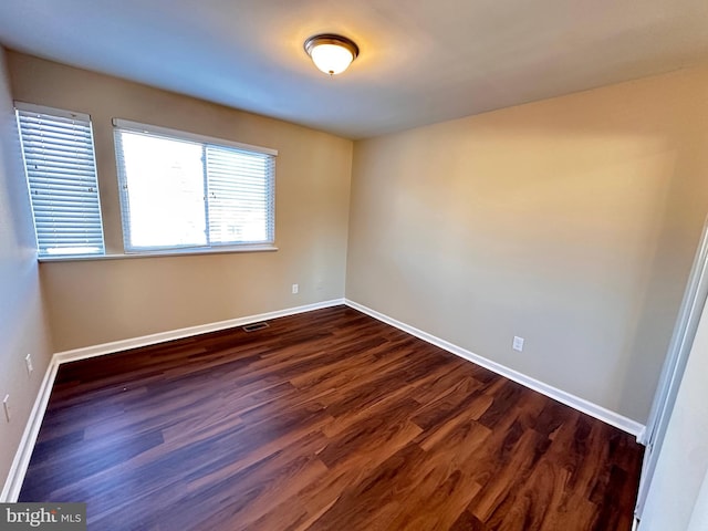 spare room featuring dark wood-type flooring