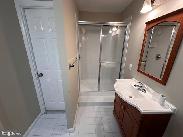 bathroom with tile patterned floors, a shower with door, and vanity