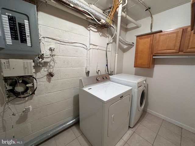 laundry room featuring cabinets, washer and dryer, electric panel, and light tile patterned floors