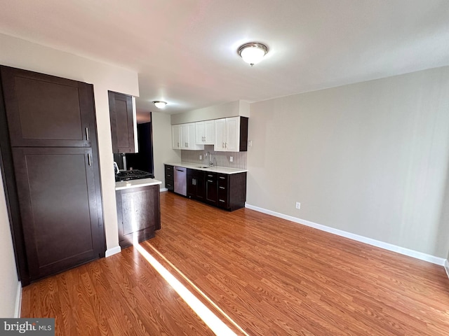 kitchen featuring light wood-type flooring, white cabinetry, sink, and stainless steel dishwasher