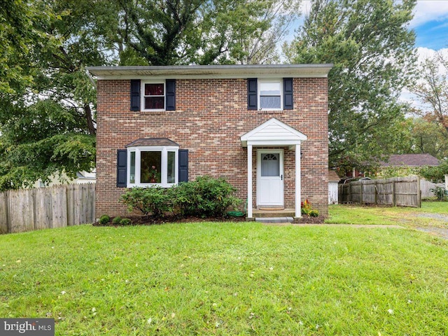 view of front of property with a front yard, fence, and brick siding