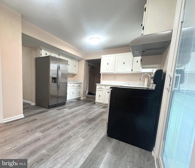 kitchen with under cabinet range hood, white cabinetry, light countertops, stainless steel refrigerator with ice dispenser, and light wood finished floors