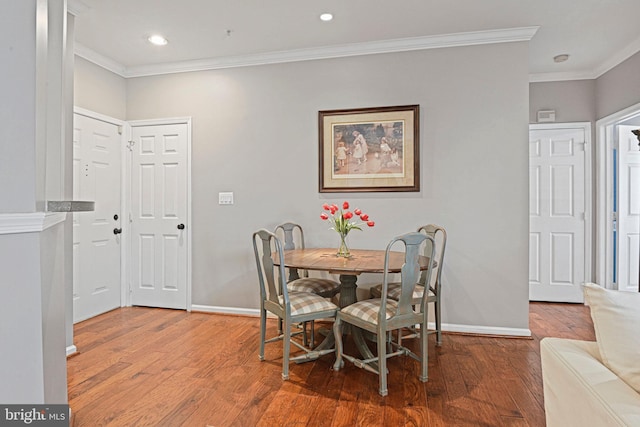 dining area with baseboards, ornamental molding, and wood finished floors