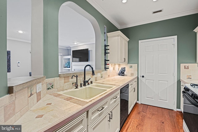 kitchen with black dishwasher, visible vents, ornamental molding, gas stove, and a sink