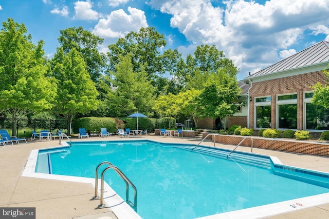 pool with a patio and fence