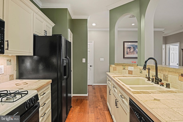 kitchen with tasteful backsplash, baseboards, dark wood finished floors, ornamental molding, and a sink