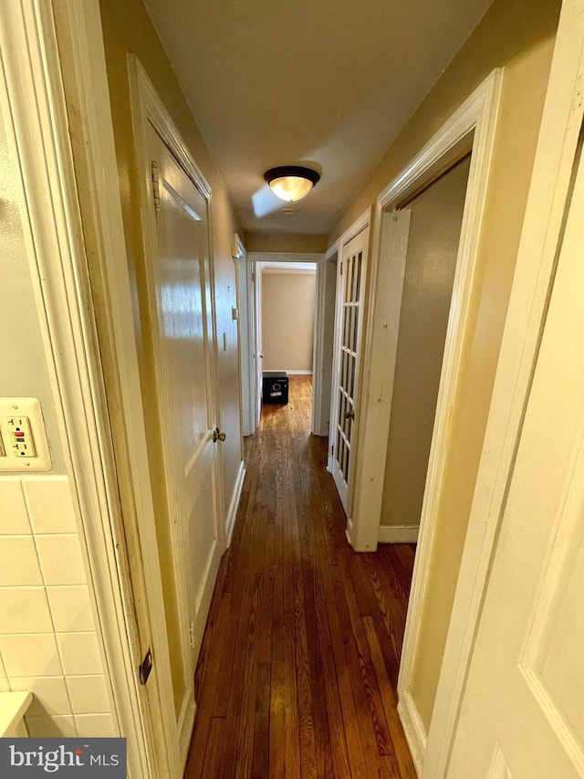 hallway featuring dark wood-style floors and baseboards