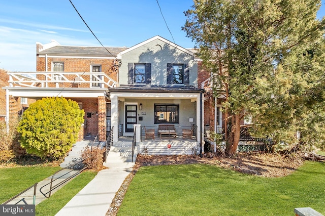 view of front of house with brick siding, a porch, a balcony, and a front lawn