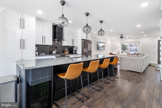 kitchen featuring stainless steel fridge with ice dispenser, decorative backsplash, dark wood-type flooring, white cabinets, and wall chimney range hood