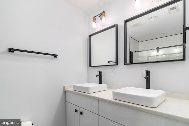 full bath featuring double vanity, visible vents, and a sink