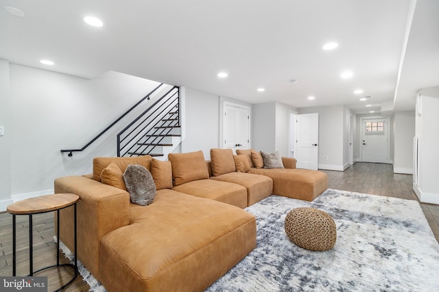 living room featuring recessed lighting, light wood-style flooring, and stairway