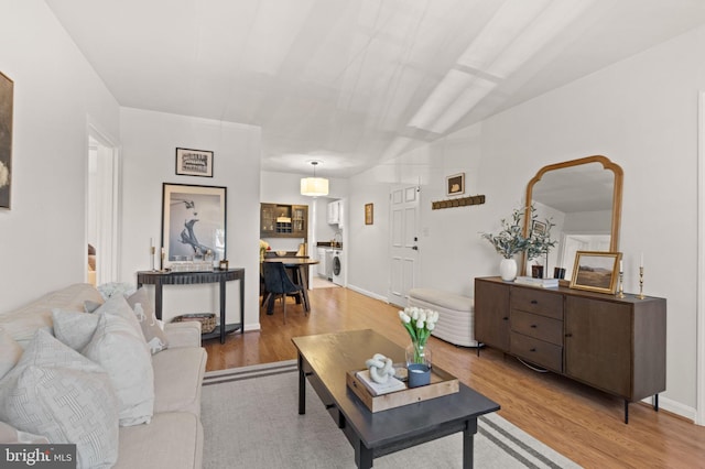 living room with light wood-type flooring and washer / clothes dryer