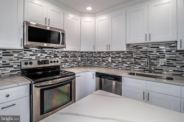 kitchen featuring sink, appliances with stainless steel finishes, white cabinets, and decorative backsplash