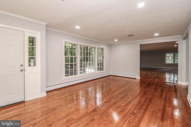 interior space featuring baseboard heating, ornamental molding, and hardwood / wood-style flooring