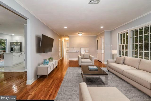 living room featuring crown molding and wood-type flooring