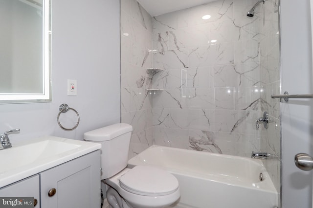 full bathroom featuring tiled shower / bath combo, toilet, and vanity