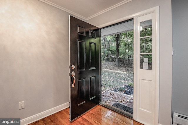 foyer entrance with wood-type flooring, crown molding, and a baseboard heating unit