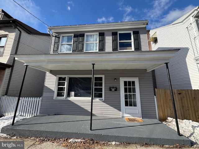 view of front of home with covered porch and fence