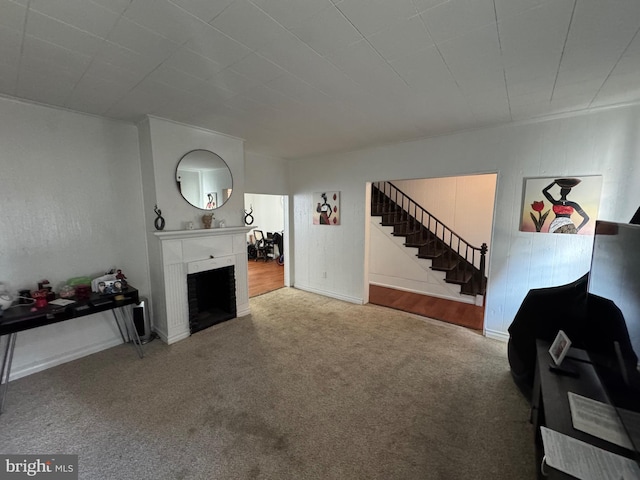 living area with carpet floors, a fireplace, and stairway