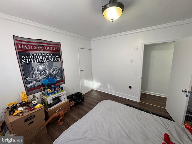 bedroom featuring dark wood-type flooring, crown molding, and baseboards