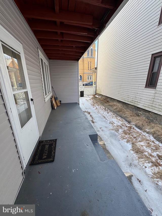 snow covered patio featuring fence