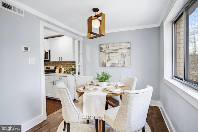 dining room with ornamental molding and hardwood / wood-style floors