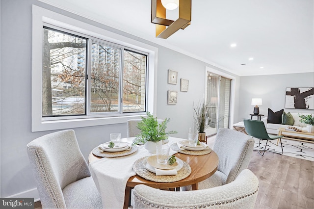 dining space with crown molding and wood-type flooring