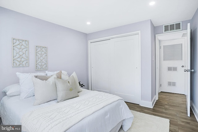 bedroom featuring dark hardwood / wood-style floors and a closet