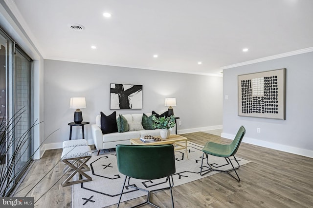 living room featuring crown molding and light hardwood / wood-style flooring